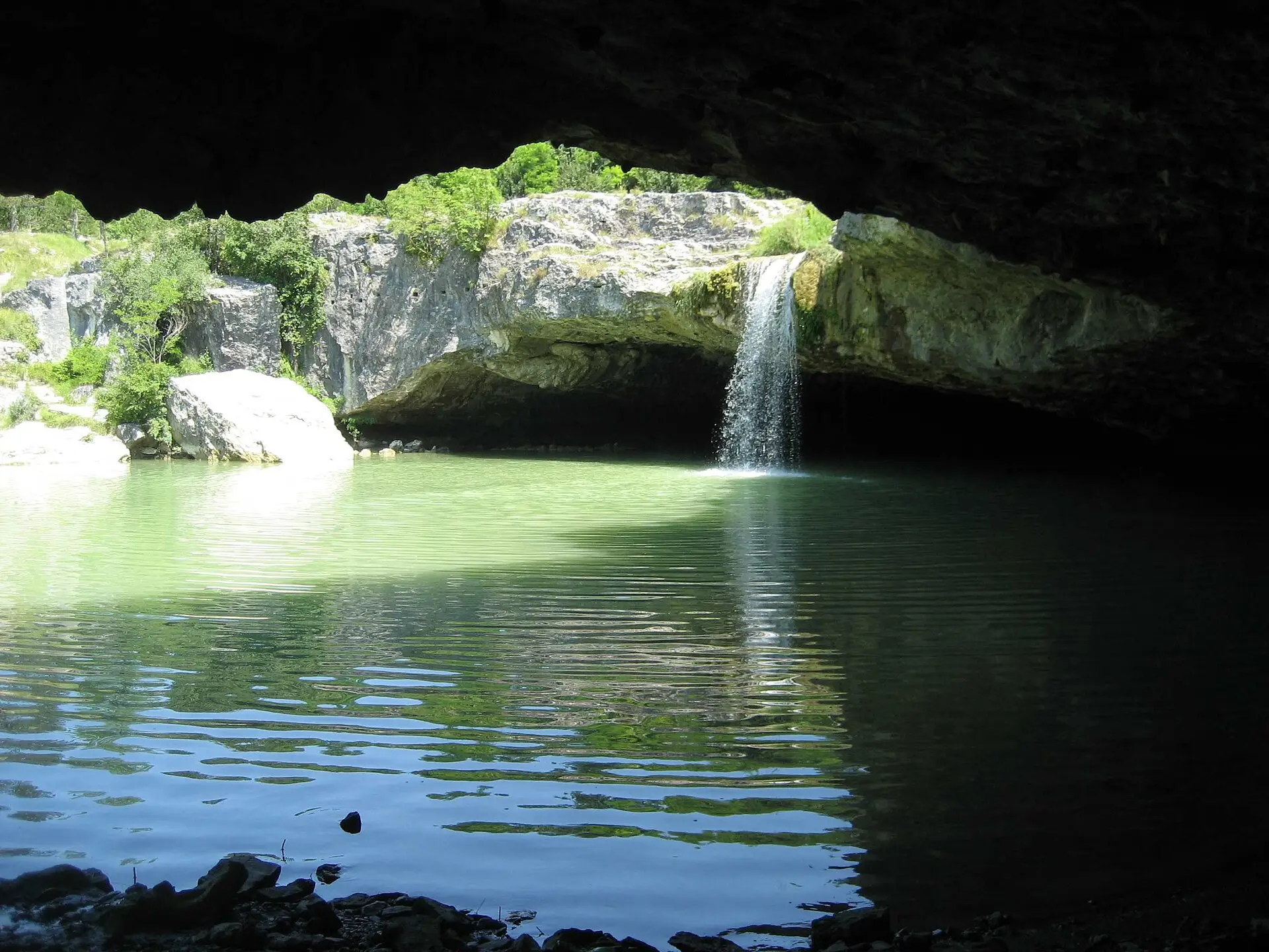The Pazinčica pouring over the wide limestone slab of Zarečki krov with the rock roof behind the water